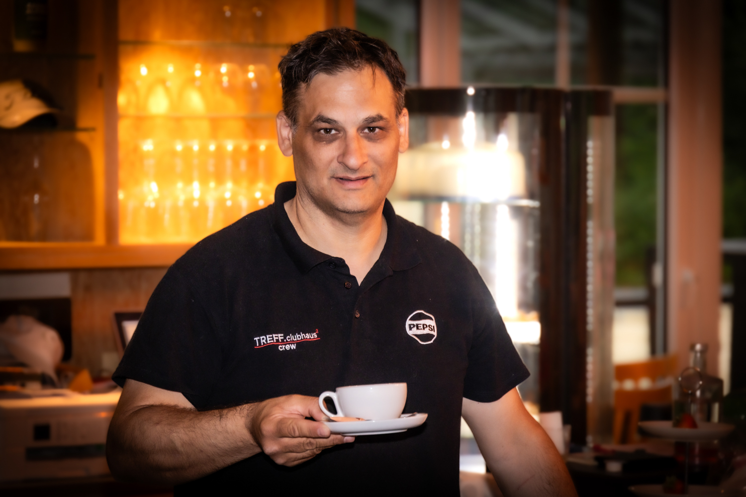 Der Gastgeber des Treff.clubhaus2 mit einer frisch zubereiteten Tasse Kaffee an der Bar